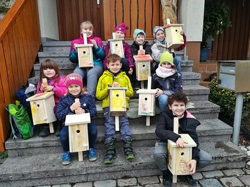 Kinder mit selbstgebauten Nistkästen